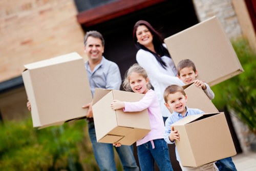 Local movers carrying furniture carefully through a residential property